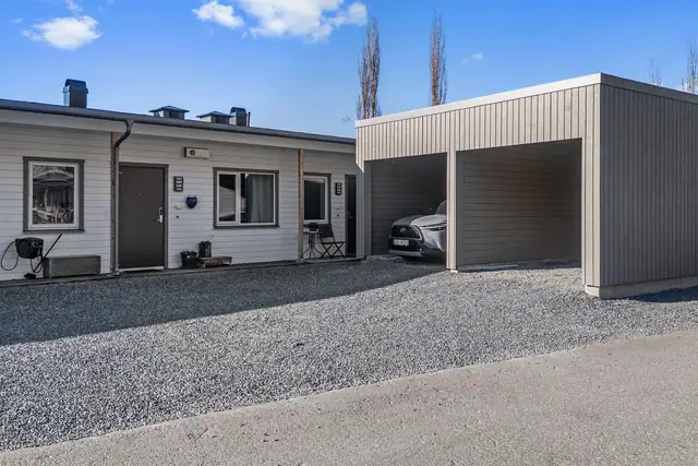 Carport med tilhørende sportsbod. Det er montert elbillader.