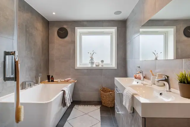 Romslig bad med god plass til både badekar og dusjkabinett. Dobbeltservant og god plass til lagring.