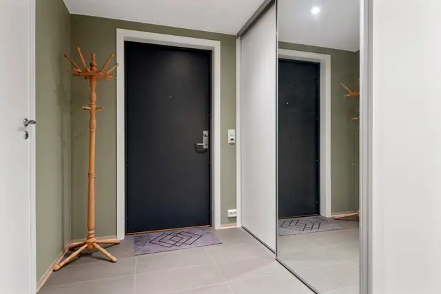 Entrè med plassbygd skyvedørsgarderobe.