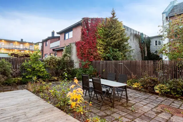 Pent opparbeidet bakgård med uteplass, utgang fra felles oppholdsrom.