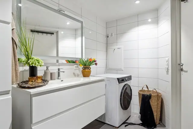 Stilrent flislagt bad av moderne standard. God plass til vaskemaskin og møblement med lagring.