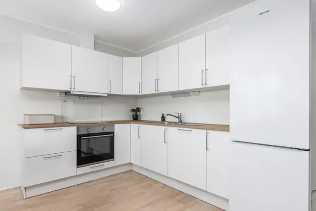Kjøkken fra JKE Design med integrert induksjonstopp, komfyr, oppvaskmaskin og mekanisk avtrekk