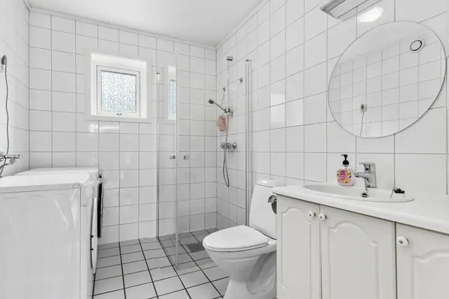 Flislagt bad med opplegg for vaskemaskin og tørketrommel.