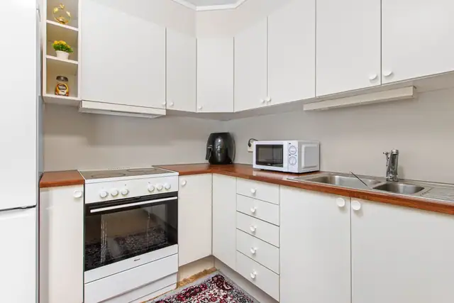 Kjøkken med opplegg for hvitevarer som komfyr, oppvaskmaskin og kjøle/fryseskap.