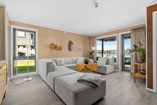 Flere store vindusflater i leiligheten gir godt med lysinnslipp og at man kan nyte utsikten fa sofaen.