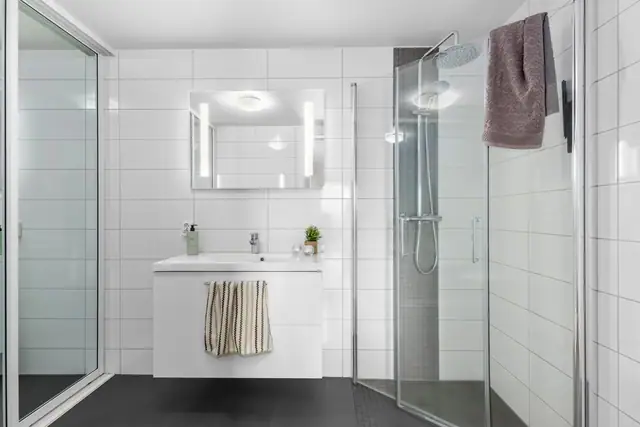 Pent flislagt bad med innfellbare dusjdører.