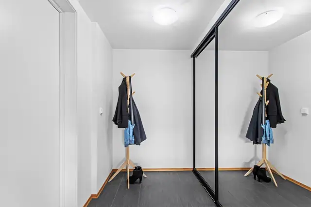 Gang med praktisk skyvedørsgarderobe, innredet med Elfa-system.