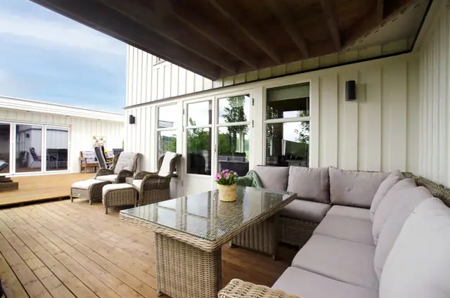 Utgang til stor og delvis takoverbygd terrasse fra stue i 1. etasje.